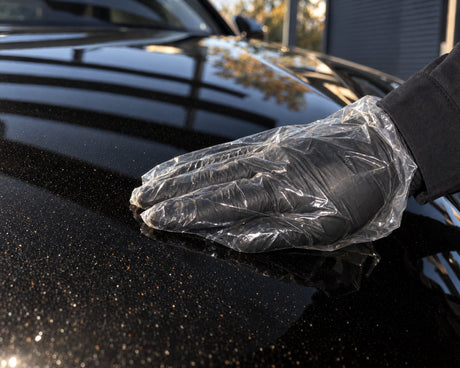 Detailing1 test dotyku na czarnym Audi RS 5 — dłoń w folii wyczuwa rdzę nalotową i pył przemysłowy na masce