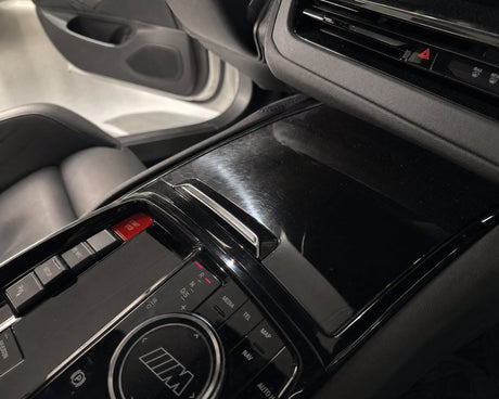Swirls auf der Klavierlack-Blende im Cockpit eines weißen BMW M5 im Streiflicht — gezeigt im Artikel „Klavierlack im Auto reinigen“