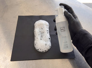 Bubbliger Schaum aus Koch-Chemie Foamer Bottle wird auf schwarzes Lederbezug-Sample im Detailing1 Warehouse aufgepumpt