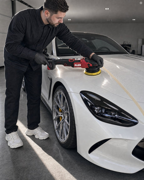 Daniel setzt den FLEX Exzenterpolierer mit einem Koch-Chemie Fine Cut Foam Pad Gelb auf der Motorhaube eines weißen Mercedes-