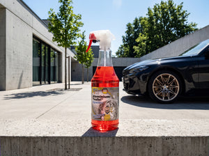 Aluminium-Teufel Rot 1L Sprühflasche auf Betonvorplatz vor schwarzem BMW M3