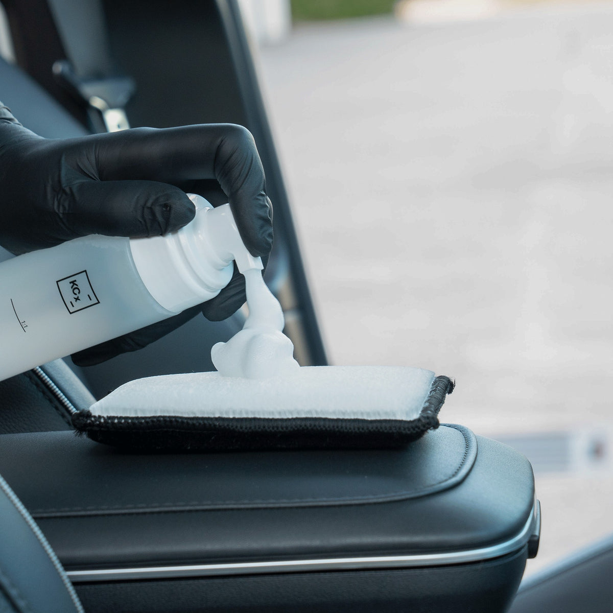 Detailing1 COLOURLOCK Leather Cleaner (Mild) — piana czyszcząca na padzie przy czarnym skórzanym podłokietniku