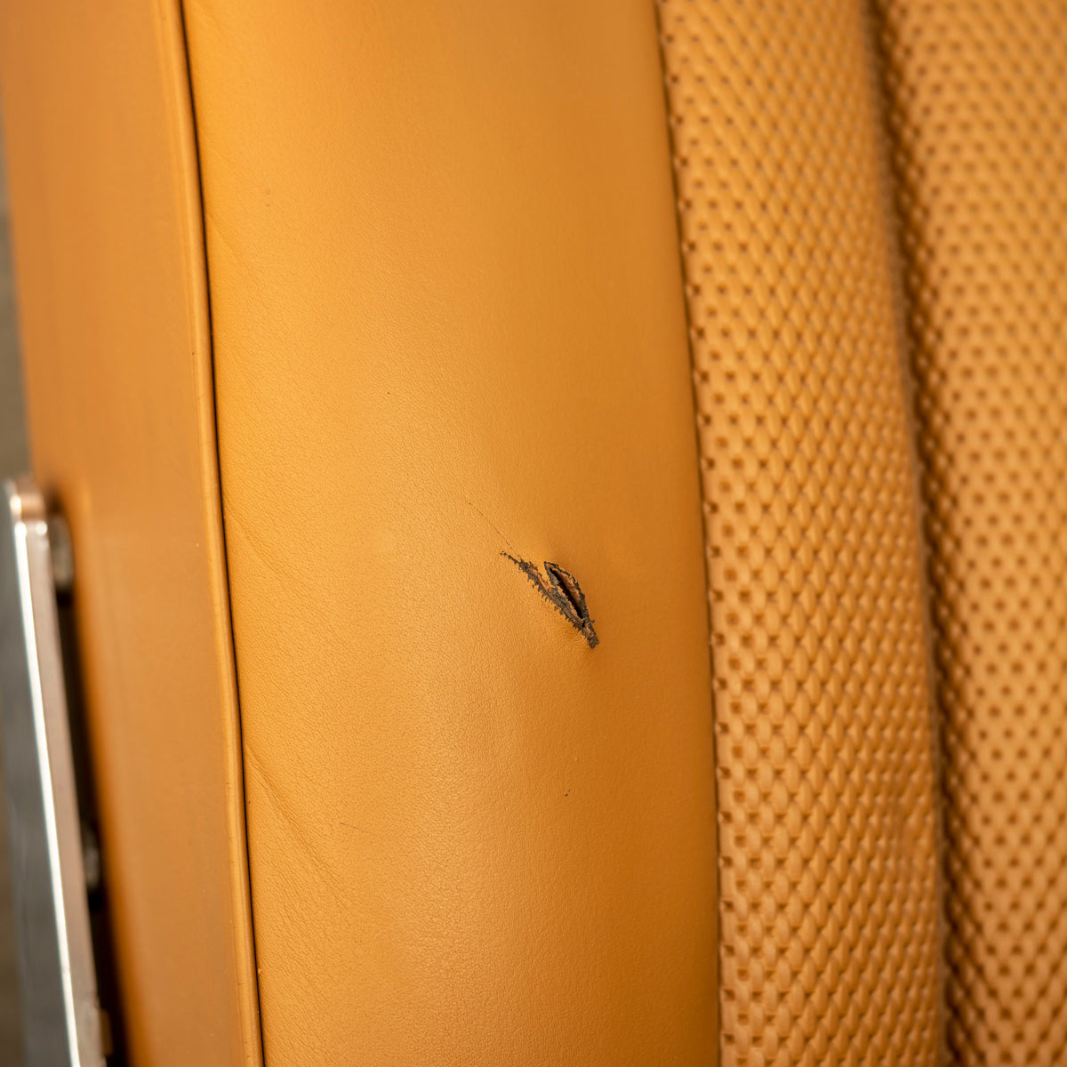 Detailing1 COLOURLOCK Risse und Löcher im Leder — Schnitt in einem cognacfarbenen Ledersitz