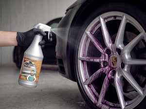 Flugrost-Teufel wird mit Nitrilhandschuh auf silberne Porsche Felge gesprüht mit deutlich sichtbarem violetten Farbumschlag an den Speichen